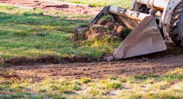 Imatge que mostra el procés detallat d´una esplanació de terreny amb maquinària d´excavació.