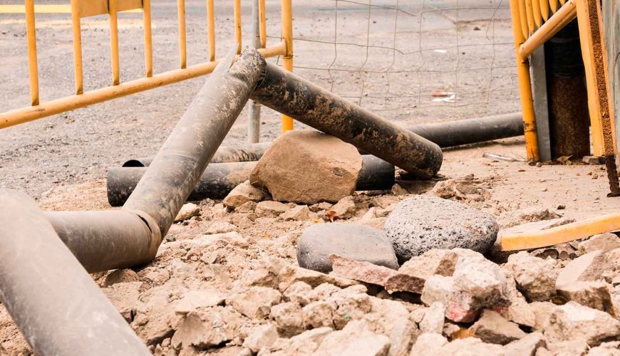 Il·lustració d'una excavadora treballant en la instal·lació de tuberies subterrànies per a xarxes de sanejament i aigua potable.